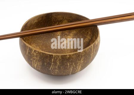 Empty coconut bowl and chopsticks isolated on white background Stock Photo