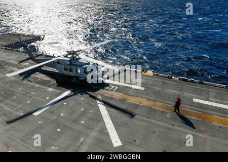 An MH-60S Sea Hawk helicopter, assigned to the “Wildcards” of Helicopter Sea Combat Squadron (HSC) 23, prepares to lift off from the flight deck aboard USS Boxer (LHD 4) as the ship steams in the Pacific Ocean, Jan. 7, 2024. The Boxer Amphibious Ready Group, comprised of Boxer, USS Somerset (LPD 25), and USS Harpers Ferry (LSD 49), and the embarked 15th Marine Expeditionary Unit are underway conducting integrated training and routine operations in U.S. 3rd Fleet. (U.S. Navy photo by Mass Communication Specialist Seaman Tyler Miles) Stock Photo