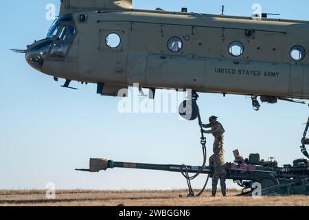 Artillery Soldiers from Charlie Battery, 3rd Battalion, 320th Field Artillery Regiment, 3rd Brigade Combat Team, 101st Airborne Division, 'Task Force 82,' conduct sling-load training and elevator drills on Mihail Kogalniceanu Air Base, Romania, Jan. 5, 2024. CH-47 Chinooks from the 3rd Attack Helicopter Battalion, 1st Aviation Regiment, 1st Combat Aviation Brigade, 1st Infantry Division, supported the 101st Airborne Division by moving M777 howitzers by air to increase readiness and proficiency in air assault operations. (U.S. Army photo by Sgt. 1st Class Jonathan Hornby) Stock Photo