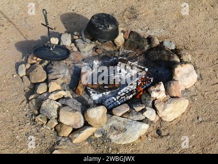 cleaning the cast iron after outdoor dutchoven cooking at the fire Stock Photo