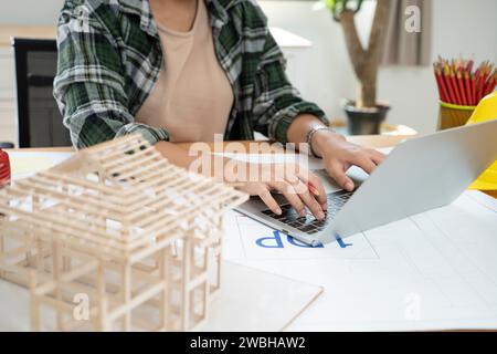 Asian architect woman working with laptop and blueprints. Stock Photo