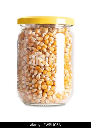 Unpopped popcorn in a glass jar with screw cap. Yellow seeds of a type of corn that expands from the kernel and puffs up when heated. Stock Photo