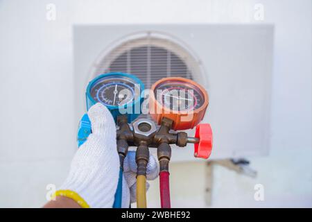 Air conditioning repair technician Air conditioning refrigerant refill gauge Stock Photo