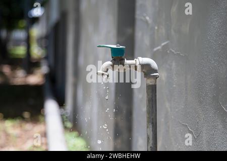 Old faucet outside the house dripping Stock Photo