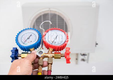Air conditioner technician checking air conditioner operation Stock Photo