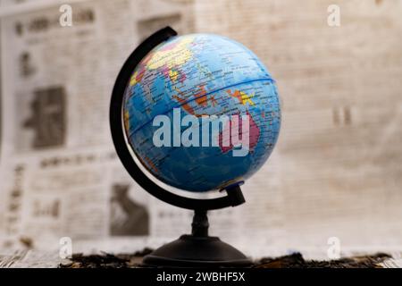 Model globe on a newspaper in the background. Stock Photo