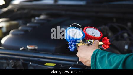 Car air conditioner check service, leak detection, fill refrigerant.Device and meter liquid cooling in the car by specialist technicians. Stock Photo