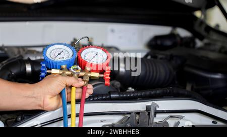 Car air conditioner check service, leak detection, fill refrigerant.Device and meter liquid cooling in the car by specialist technicians. Stock Photo