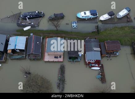 Flooding is still a problem as it surrounds these boat owners chalets in Peterborough after the River Nene breached its banks at Orton Mere in Peterborough, Cambridgeshire, on 8th January 2024. Stock Photo