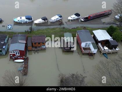 Flooding is still a problem as it surrounds these boat owners chalets in Peterborough after the River Nene breached its banks at Orton Mere in Peterborough, Cambridgeshire, on 8th January 2024. Stock Photo