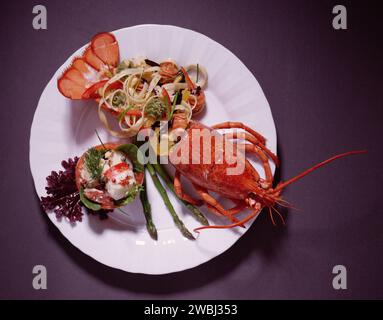 Lobster with lemon and salad on a plate with garnish Stock Photo