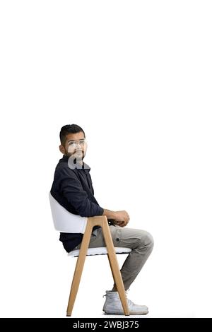 A man, on a white background, in full height, sitting on a chair Stock Photo