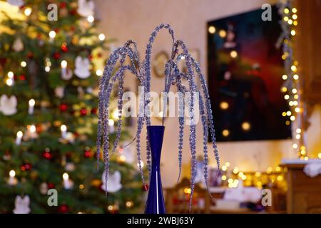 Christmas Table Decoration with hanging Glitter Branches in festively Decorated Family Room Stock Photo