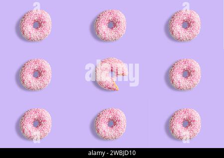 Collage of pink doughnuts in glaze on a pink background. Lots of donuts mosaic, a tasty fresh pink donut drizzled with glaze. One donut in the center Stock Photo