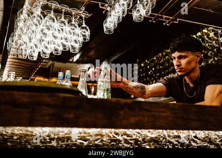 April 17, 2023 - Porto, Portugal: Portuguese barman working in the bar and preparing drinks Stock Photo