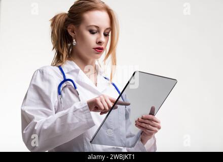 With a bright smile, medic holds a futuristic transparent tablet, signaling modern treatments Stock Photo