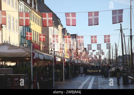 Kopenhagen Denmark 11th Jan 2024 A Passer By Walks Past   Kopenhagen Denmark 11th Jan 2024 Nyhavn One Of The Biggest Sights Is Decorated With Danish Flags Ahead Of The Change Of Throne In Denmark The Danish Queen Margrethe Ii Will Abdicate On 14012024 After 52 Years On The Throne And Pass The Office On To Her Eldest Son The Current Crown Prince Frederik Credit Steffen Trumpfdpaalamy Live News 2wbjm4j 