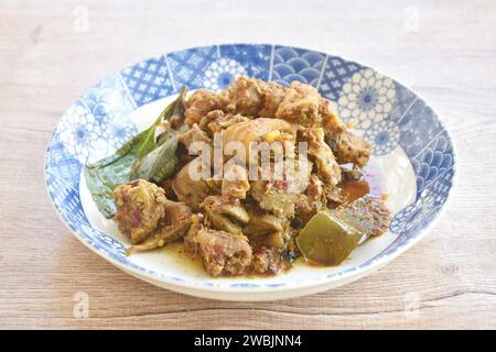 spicy fried chop chicken bone with basil in chili curry sauce on plate Stock Photo