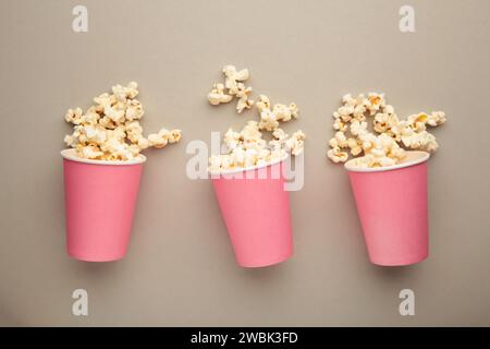 Popcorn in pink cups. Three cups of popcorn on grey background. Sweet popcorn. Top view Stock Photo