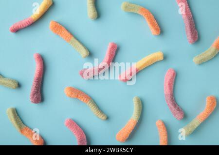Top view of colorful gummy jelly worm candies on blue background. Stock Photo