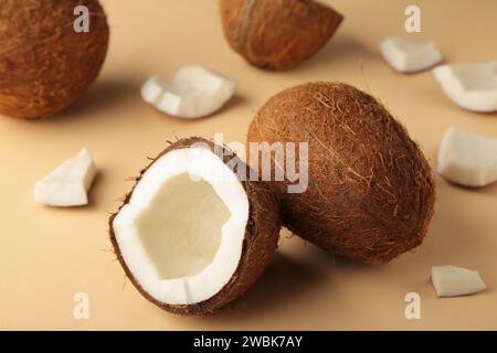 Coconut on a beige background. Halves and whole coconuts. Stock Photo