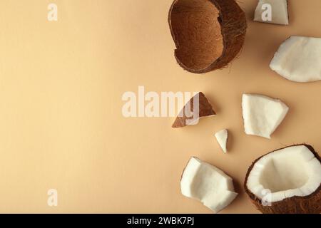 Coconut on a beige background. Halves and whole coconuts. Stock Photo