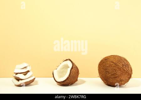 Coconut on a beige background. Halves and whole coconuts. Stock Photo