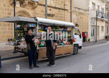 Zebbug, Malta - 19 December, 2023: mobile greengrocer and senior citizen customer in a remote village on Gozo Island in Malta Stock Photo