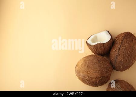 Coconut on a beige background. Halves and whole coconuts. Stock Photo