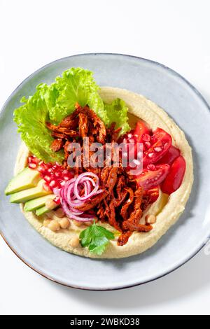 Hummus with vegan meat in barbecue sauce, tomato and avocado salad. A healthy bowl Stock Photo