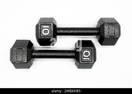 Two black steel ten pound dumbbell weights on a solid white background Stock Photo