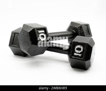 Two black steel ten pound dumbbell weights on a solid white background Stock Photo
