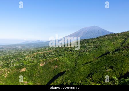 Bali island landscape. Beautiful mountains covered by green jungle. Agung volcano on clear day. Sunny day at Bali island, Indonesia. With space for te Stock Photo