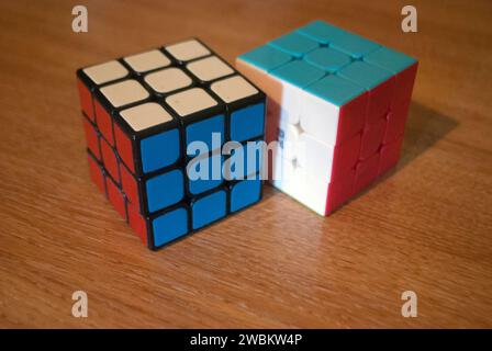 Two rubik's cubes on a desk showing red white and blue sides Stock Photo