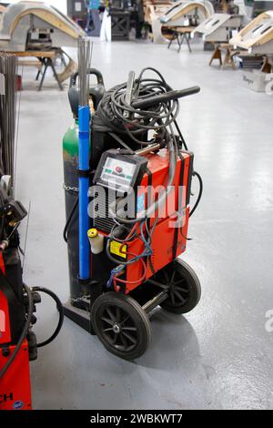 A welding machine on wheels with various wires and equipment in a workshop environment. portable gas welder in the morgan factory in malvern worcester Stock Photo