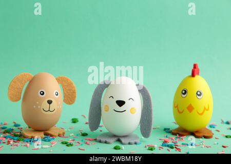 Easter holiday concept with cute handmade eggs, dogs, chicks and cat on mint background. Top view. Happy Easter Stock Photo