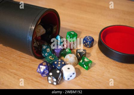 Dice spilling from black dice cup Stock Photo