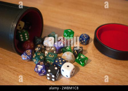 Dice spilling from black dice cup Stock Photo