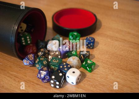Dice spilling from black dice cup Stock Photo