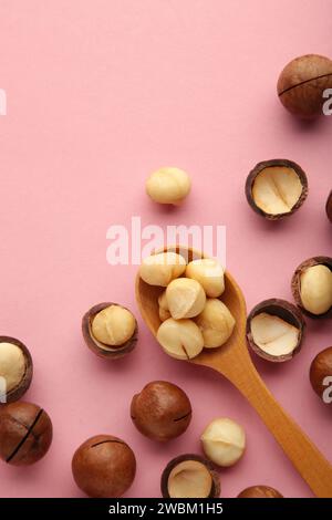 Macadamia in wooden spoon on pink background. Favorite for snack and very delicious.Have a lot of unsaturated fatty acid. Healthy food concept. Top vi Stock Photo