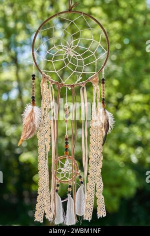 Dream catcher and green trees on the background. Stock Photo