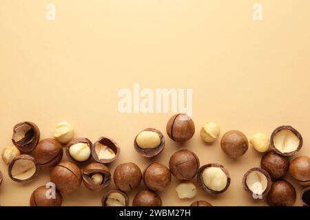 Peeled macadamia nuts on the beige background. Top view. Stock Photo