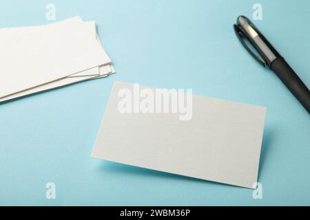 Blank white business cards on blue paper background. Mockup for branding identity. Template for graphic designers portfolios. Stock Photo