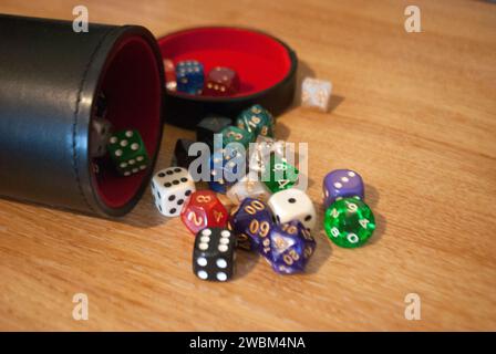 Dice spilling from black dice cup Stock Photo