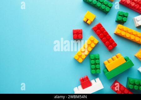 Multicolored blocks of the children's constructor lie on a blue background Stock Photo