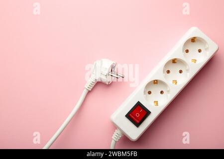 Electric white portable socket on pink background Stock Photo