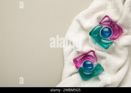 Washing gel capsule pods with laundry detergent on a pile of white cloth background. Stock Photo
