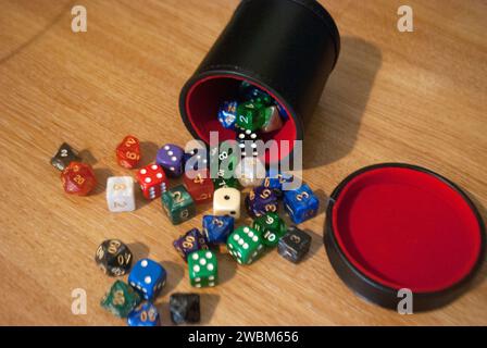 Dice spilling from black dice cup Stock Photo