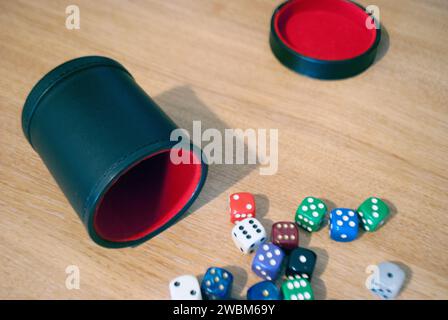 Dice spilling from black dice cup Stock Photo
