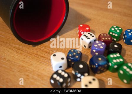 Dice spilling from black dice cup Stock Photo